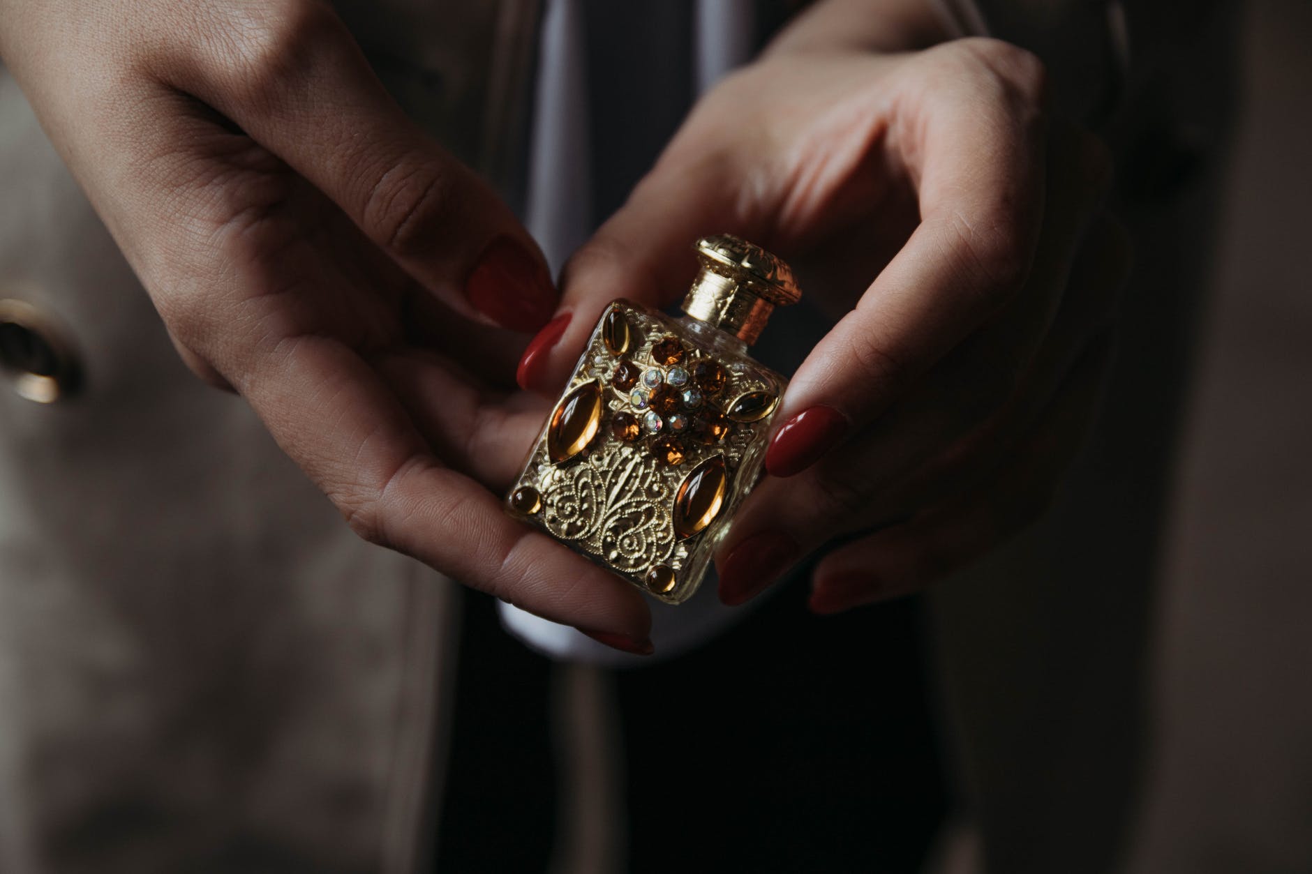 anonymous woman showing retro miniature ornamental perfume bottle